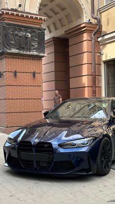 a blue sports car parked in front of a building