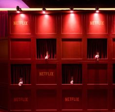 red curtains with netflix written on them in front of a purple wall and stage curtain