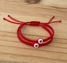 The Red String of Fate is a story of destiny that explains how people are meant to be together. They are linked by a red string attached to their hands until they find each other. It is also believed that the red string helps to channel positive energy for good luck and provide protection against evil. Bracelet Features: (1) 1mm Durable Nylon Cord (2) Bracelet is adjustable to fit most wrist sizes (3) Bracelet thickness (width) is 5mm (4) 7mm Acrylic Heart Bead Matching Bracelets String, Matching Beaded Bracelets For Couples, Red Braided Bracelets For Valentine's Day, Matching String Bracelets, Couple Beaded Bracelets, Cute Matching Bracelets, Nylon String Bracelet, Matching Heart Bracelet, Red Bracelet For Protection