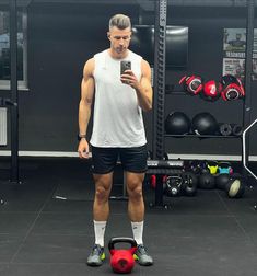 a man taking a selfie with his cell phone in the middle of a gym