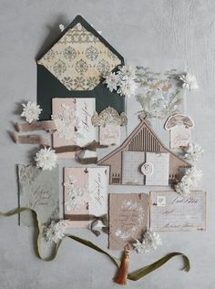 an assortment of cards and envelopes with flowers on the top, along with other items