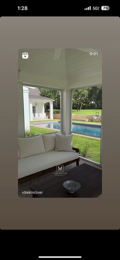 a couch sitting on top of a wooden floor in front of a glass wall window