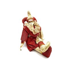 a figurine is sitting on the floor with his legs crossed and hands behind his head