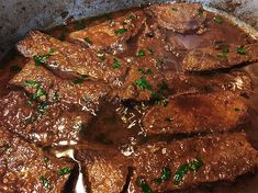 meat and gravy are in a pot on the stove top, ready to be cooked