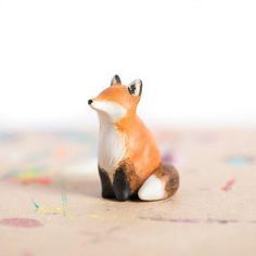 a small toy fox sitting on top of a table