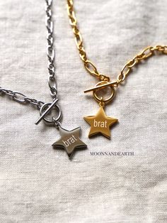 This star shaped chunky necklace features an engraving of the word 'brat' on the front. Material: Stainless Steel with high-quality 18k high-polished PVD vacuum plating. Hypoallergenic, lead & nickel free, rust/tarnish free, waterproof, color will not change/fade & will not turn your skin black or green. Available in gold & silver! Chain Length: 16 in.  Pendant Size: 20 mm diameter 2 mm thick All Purchases are shipped with tracking! Each necklace is packaged in a jewelry box along with a polishing cloth ready to be sent as a gift. Feel free to add a gift message after marking it as a gift <3 Shop Policies: We accept returns and exchanges. The buyer is responsible for return shipping costs and any loss in value if an item isn't returned in its original condition.  If you have any other ques Brat Necklace, Valentine's Day Silver Brass Necklace, Nickel-free Brown Metal Necklace, Vintage Charm Heart-shaped Brass Necklace, Nickel-free Bronze Brass Charm Necklaces, Star Necklace Gold, Chunky Necklace, Size 10 Rings, Star Necklace