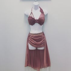 a mannequin dressed up as a belly dancer in front of a white wall