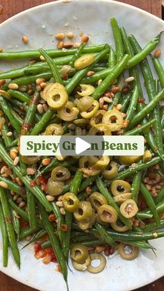 green beans and olives on a white plate with the words spicy grn beans