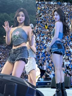 two women in short shorts and high heels are on stage at a concert with an audience behind them