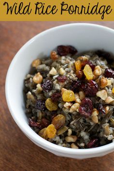 a white bowl filled with wild rice and raisins on top of a wooden table