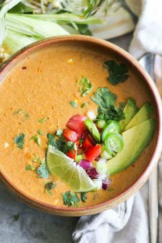 a bowl filled with soup and garnished with avocado