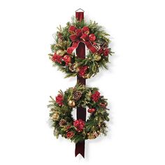 two christmas wreaths are hanging on a pole