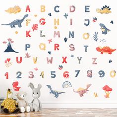 children's wall decals with dinosaurs and letters on the wall in a playroom