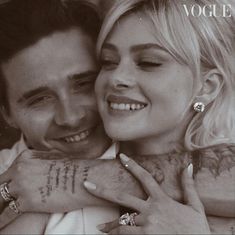 a man and woman hugging each other with tattoos on their arms