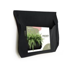 a potted plant hanging from the side of a black wall mounted holder on a white wall