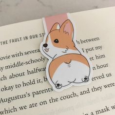 a book with a sticker of a corgi laying on it's side