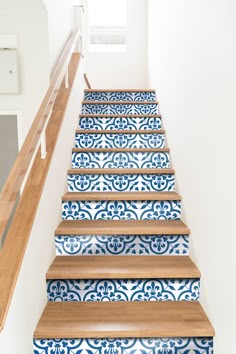 blue and white tile stair treads with wooden handrail