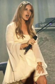 a woman in white dress holding a microphone