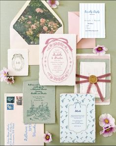 the wedding stationery is laid out on top of each other, including envelopes and cards