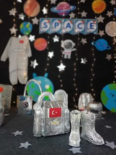 space themed birthday party with shiny silver shoes and bags on the table in front of an outer space backdrop