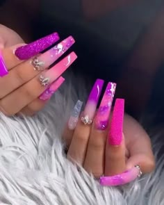 a woman's hands with pink and purple nail polish