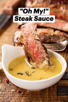 a piece of meat is being dipped into a bowl of soup on a cutting board