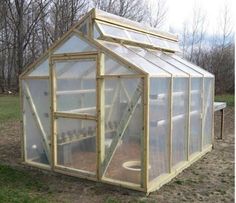 a small green house sitting in the middle of a field