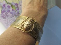 "Myelegantthings presents a gorgeous Scarab Beetles cuff.bracelet. I made these in 1970's for my jewelry line, \"Angelina Verbuni Designs\" 1 inch engraved cuff opens in back The scarab is about 1 inch. 18 K matt gold plating over brass All brass vintage findings. Chic! I have other bangles I've made also with bumble bees, panthers, butterflies and lions and lots of necklaces to match also. Available in silver or gold All USA made" Adjustable Gold Victorian Cuff Bracelet, Vintage Gold Cuff Jewelry, Antique Gold Cuff Bracelet Collectible, Nickel-free Vintage Bangle As A Gift, Silver Brass Cuff Bracelet For Wedding, Victorian Gold Cuff Bracelet Gift, Antique Hallmarked Cuff Bracelet For Gift, Vintage Brass Cuff Jewelry, Vintage Bronze Cuff Jewelry