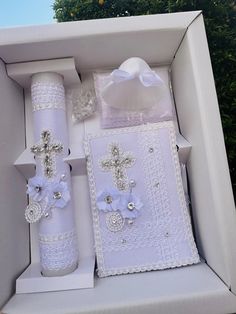 a white box with two items in it and a cross on the front, inside which is decorated with flowers