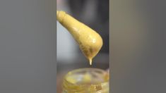 a spoonful of lemon juice being poured into a jar