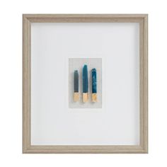 two blue and gold candles in a white frame