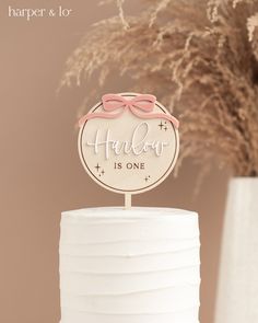 a white cake topped with a pink bow and an inscription on the top that reads, hollow is one