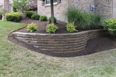 a brick retaining wall in front of a house