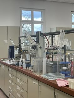 a lab filled with lots of bottles and beakles on top of a counter next to a window