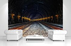 a train track going through a tunnel with lights at the end wall mural decal