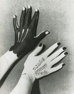 black and white photograph of two hands with tattoos on them