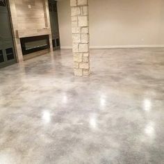 an empty room with a fireplace in the center and no one around it on the floor