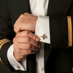 a close up of a person wearing a suit and tie with his hands on his lapel