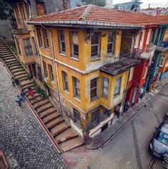 an aerial view of some old buildings in the middle of a street with cars parked on the side