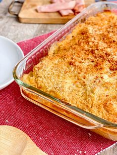 a casserole dish with meat and cheese in it sitting on a red place mat