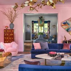 a living room filled with blue couches and pink walls