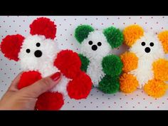 three small teddy bears made out of pom - poms are being held by a person's hand