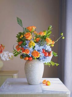 a white vase filled with lots of colorful flowers