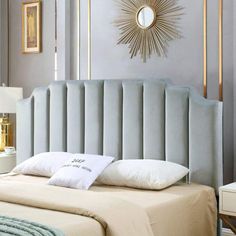 a bed with a light blue headboard and white pillows