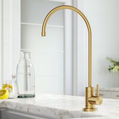 a gold faucet on a marble counter top