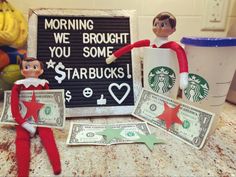 an elf is sitting on top of money next to a sign that says morning we brought you some starbuckss