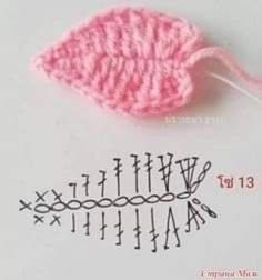 a crochet leaf and needles on top of a piece of paper