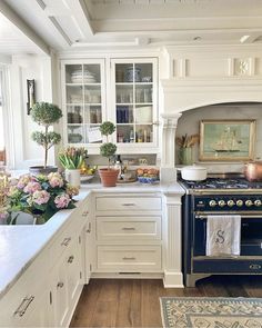 a kitchen filled with lots of white cabinets and counter top space next to an oven