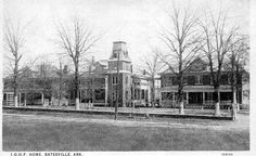 an old black and white photo of a building with a clock on it's tower