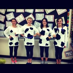 four girls dressed in cow costumes standing next to each other with their hands on their hips